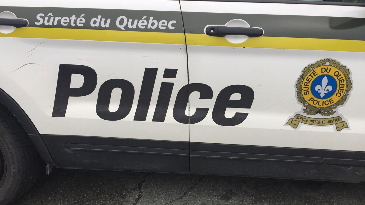 Porte d'une voiture de police de la Sûreté du Québec avec le logo.