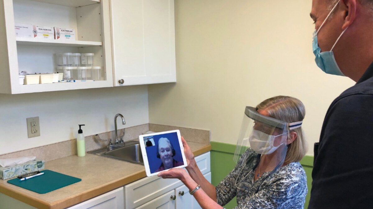 Un homme parle à un interprète via l'application Voyce installée sur une tablette.