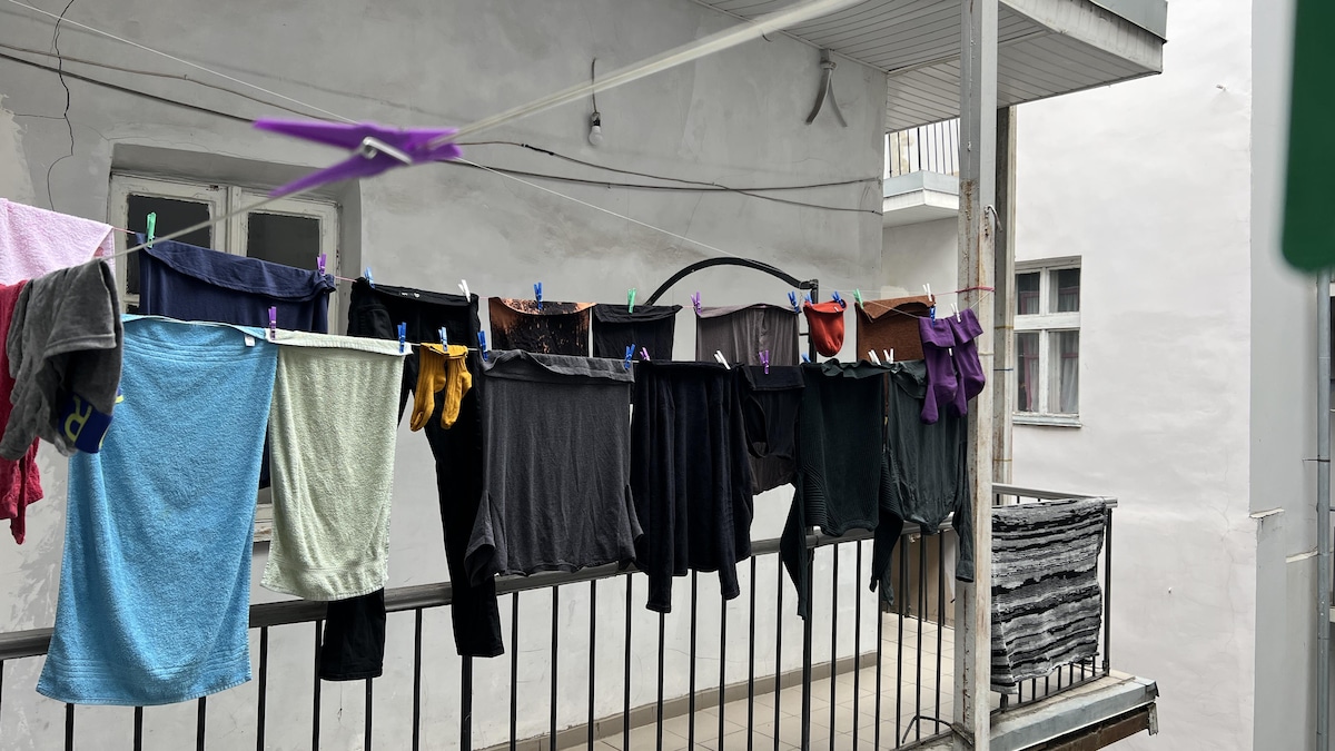 Des vêtements accrochés à sécher au-dessus d'un balcon.