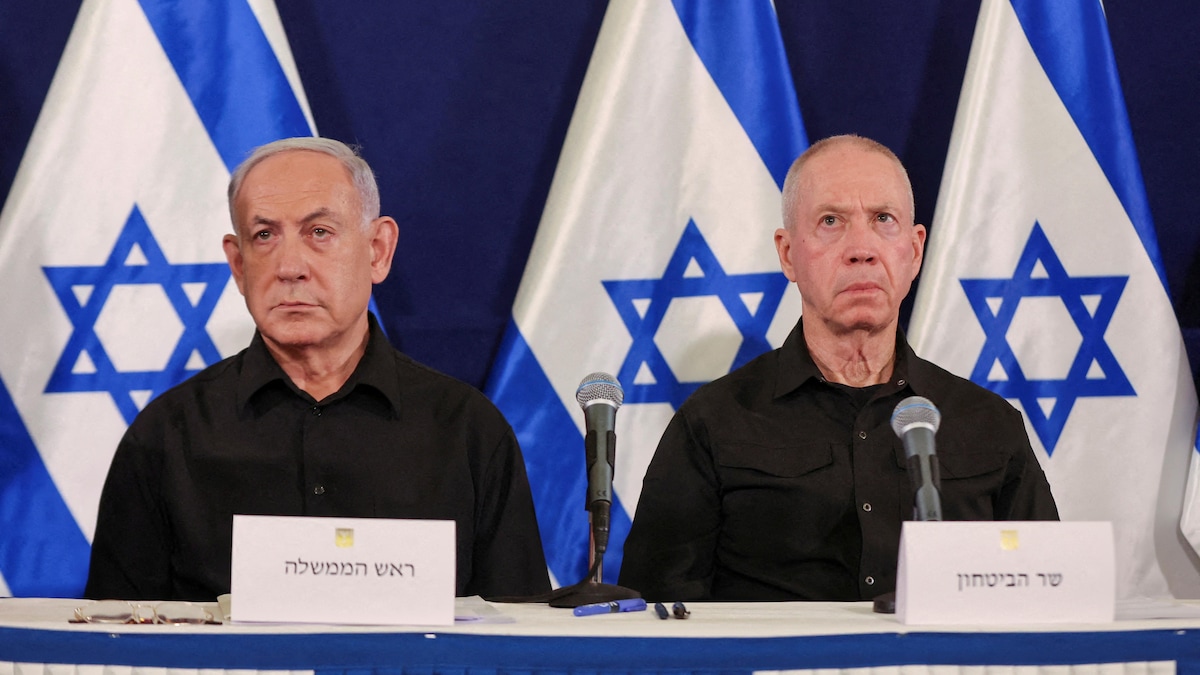 MM. Nétanyahou et Gallant sont assis devant des drapeaux d'Israël.