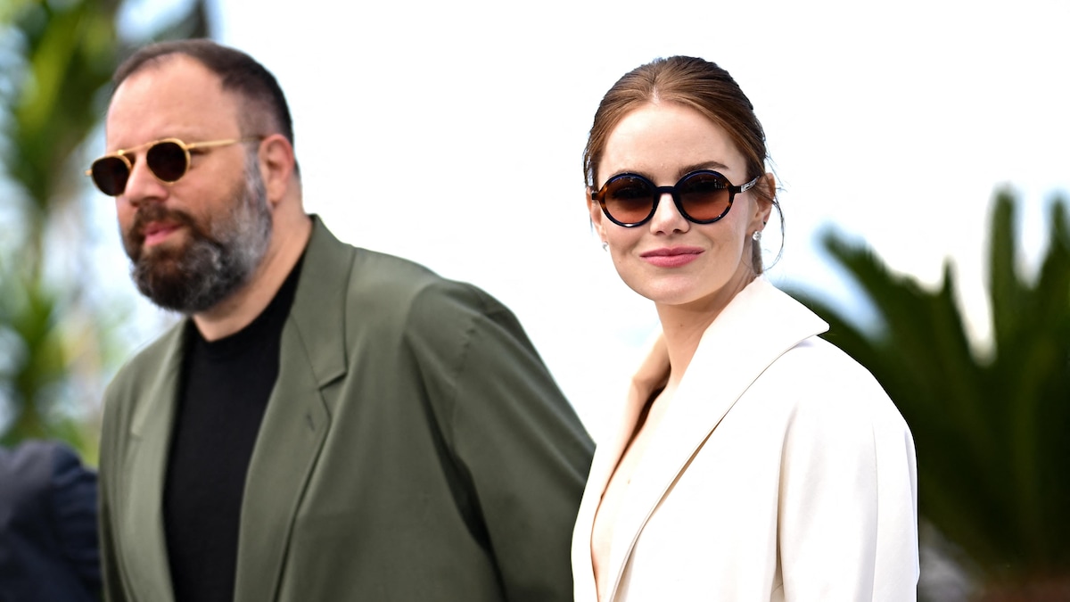 Yorgos Lanthimos et Emma Stone sont à l'extérieur et portent des lunettes de soleil.