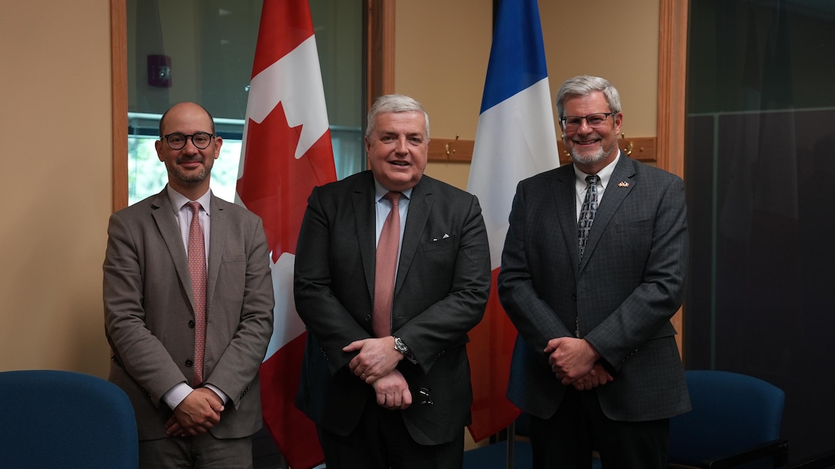 Nicolas Baudouin, Michel Miraillet et Erik Hougen devant les drapeaux canadien et français le 30 mai 2024.     