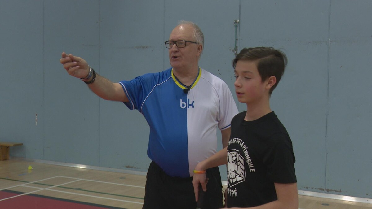 Yves Côté donne une explication à un jeune joueur de badminton.