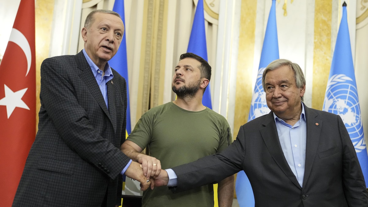 Le président ukrainien Volodymyr Zelensky, au centre, le président turc Recep Tayyip Erdogan, à gauche, et le secrétaire général des Nations Unies Antonio Guterres se serrent la main.