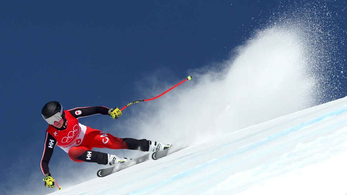 Une skieuse est en pleine action. Elle entraîne dans son sillage une longue trainée de neige.
