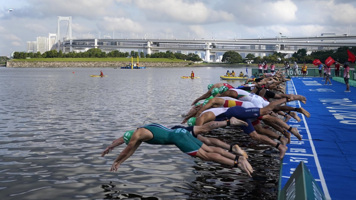 Athletes dive into the water for the start of the men's individual triathlon at the 2020 Summer Olympics, Monday, July 26, 2021, in Tokyo, Japan. (AP Photo/Jae C. Hong)