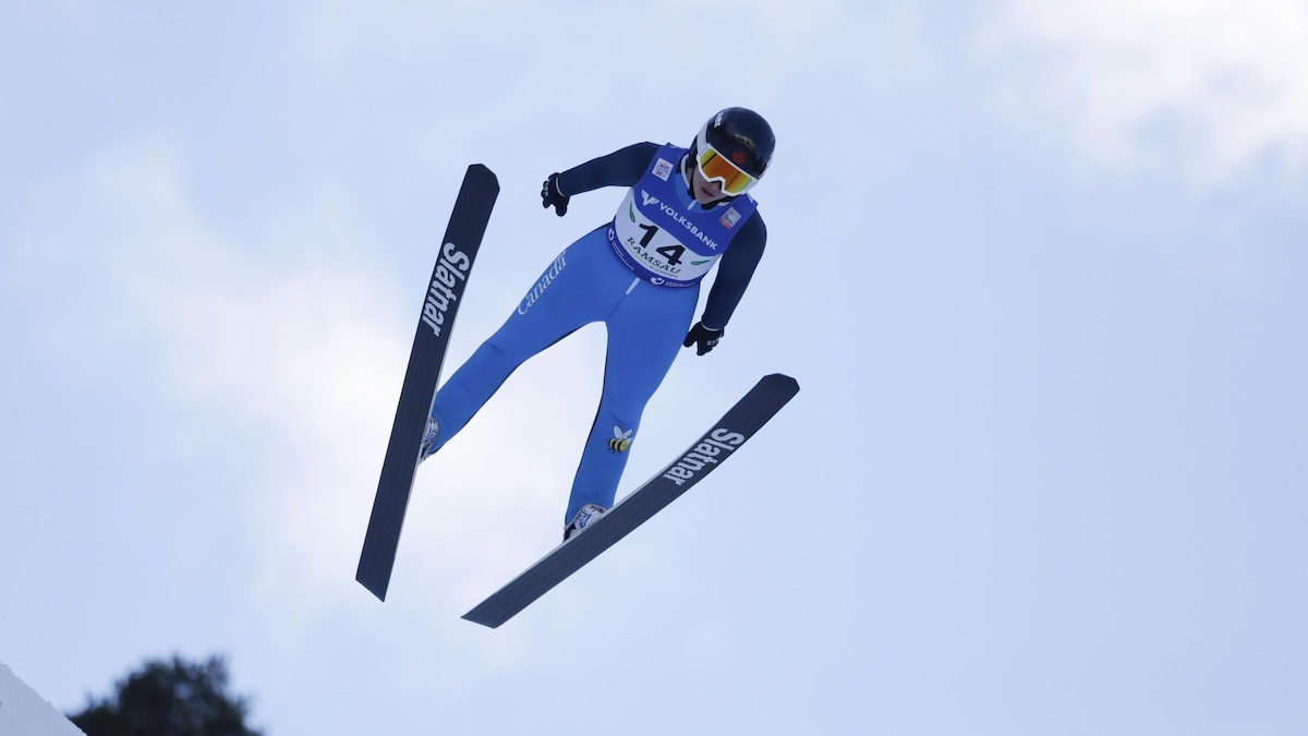 Une athlète effectue un saut à ski.