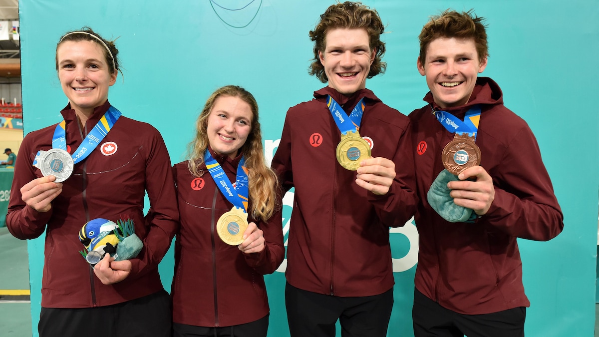 Les quatre athlètes montrent leur médaille avec fierté.