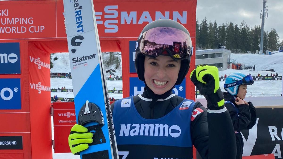 La sauteuse à ski Alexandria Loutitt au bas de la piste sa paire de skis en main.