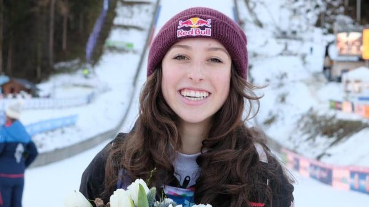 Une athlète de saut à ski souriante avec ses fleurs pour sa 3e position.