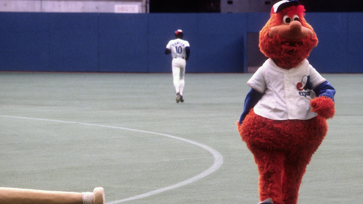 Une mascotte marche sur un terrain de baseball.