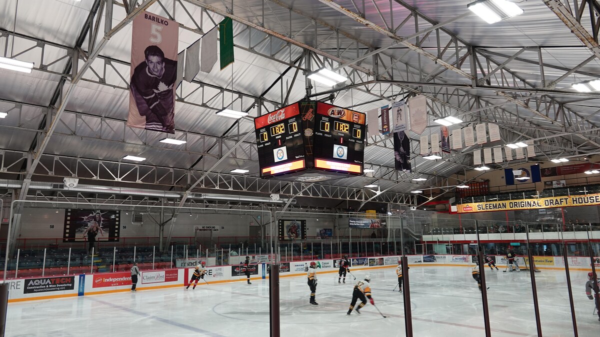 Une bannière est accrochée au plafond de l'aréna McIntyre. On y voit un ancien joueur des Maple Leafs de Toronto et le numéro 5.