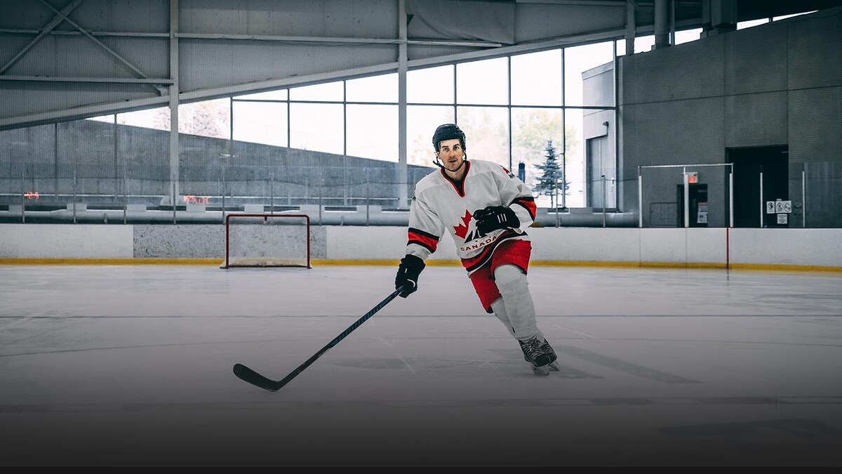 Le journaliste Michaël Roy sur une patinoire vêtu d'un équipement de hockey.