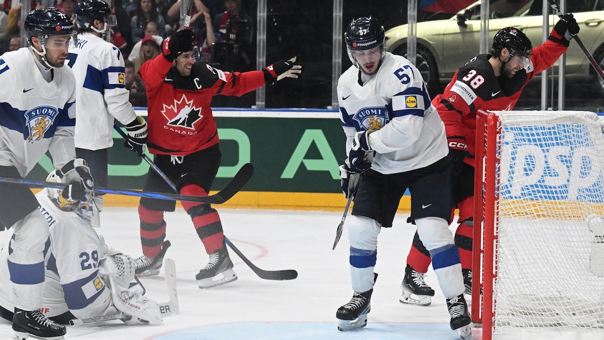 Deux joueurs du Canada lèvent les bras, au grand dam des joueurs finlandais.