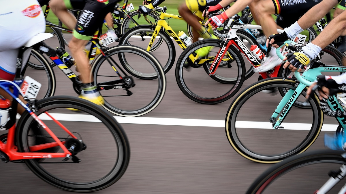 Des cyclistes roulent très près les uns derrière les autres.