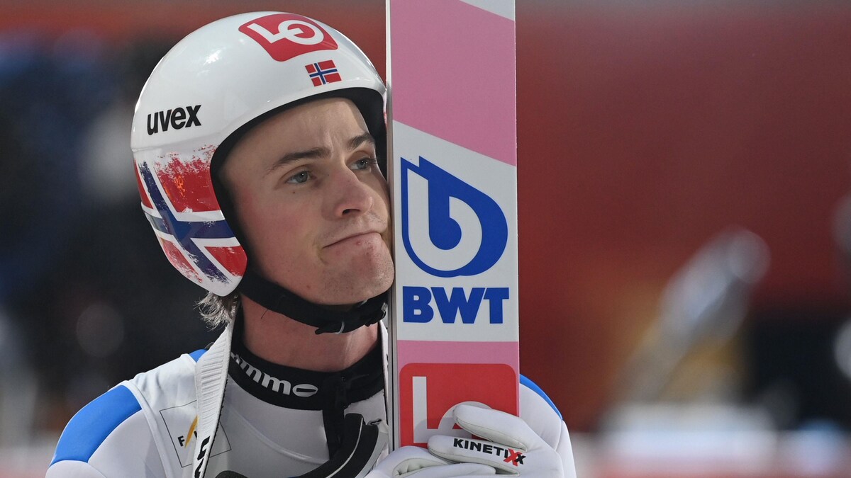 Daniel-Andre Tande tient ses skis près de son visage en attendant le résultat de sa descente.