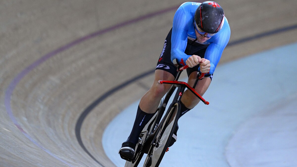 Un cycliste sur piste performe lors d'une compétition.