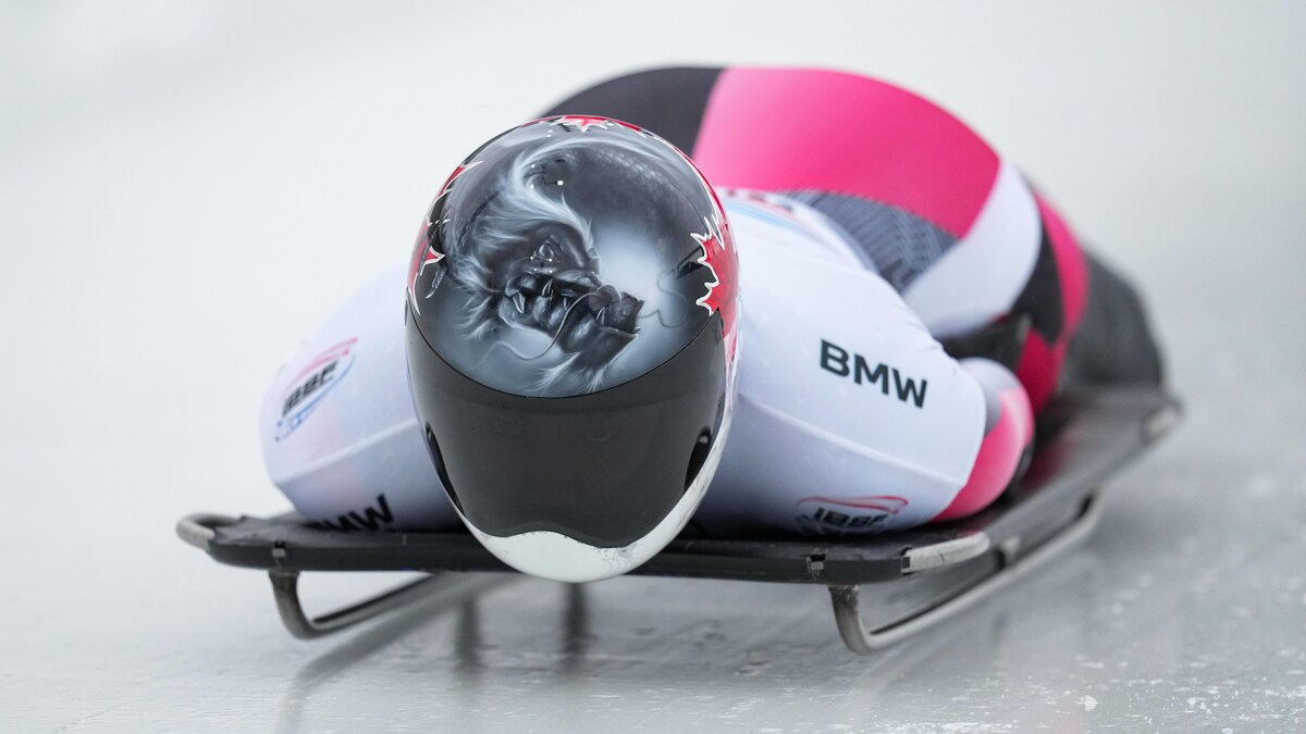 Une athlète descend la piste en skeleton.