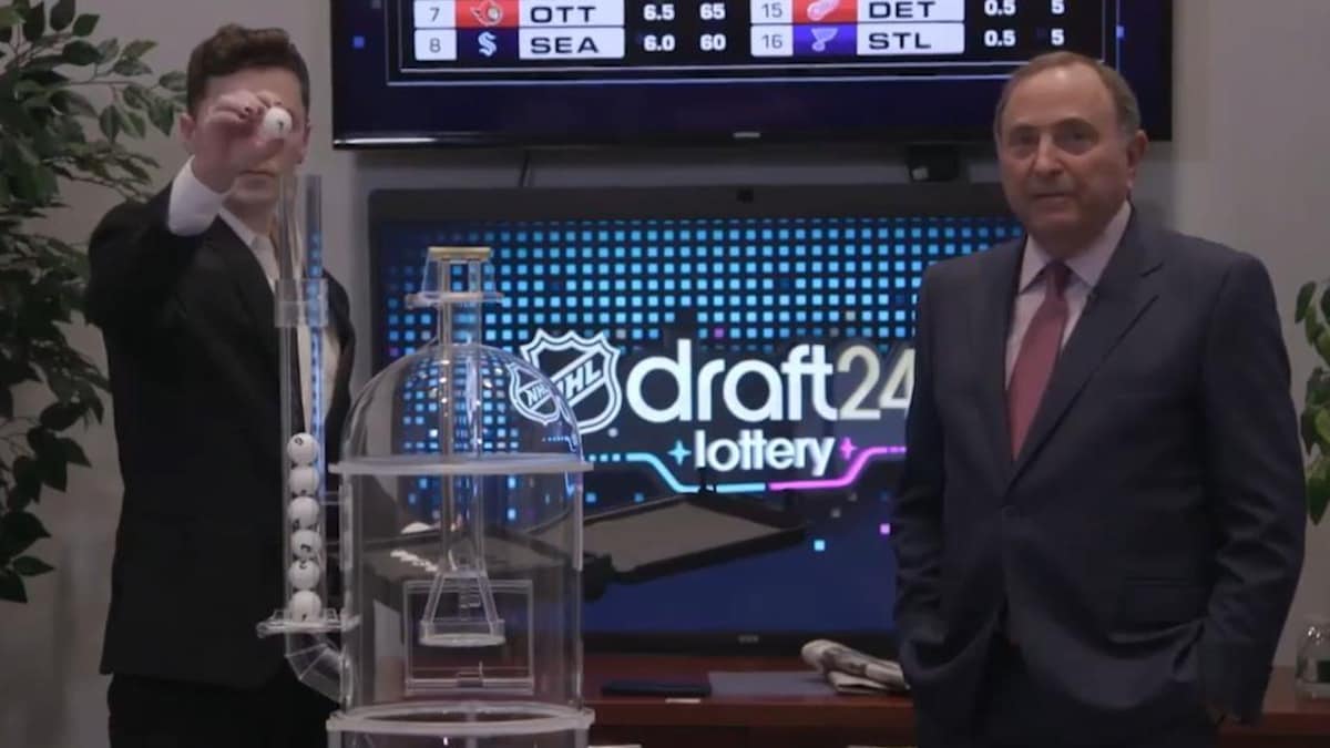 Un homme pose à côté d'un boulier. On peut lire à l'arrière-plan : NHL draft24 lottery.