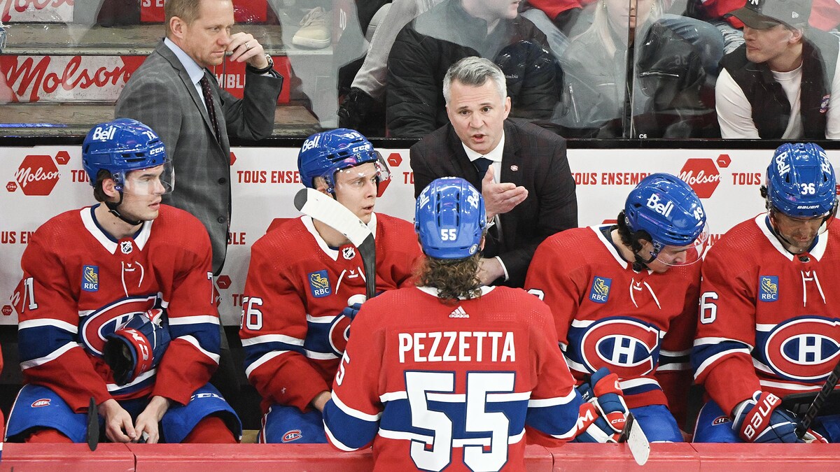 Un entraîneur donne des directives à un groupe de hockeyeurs.