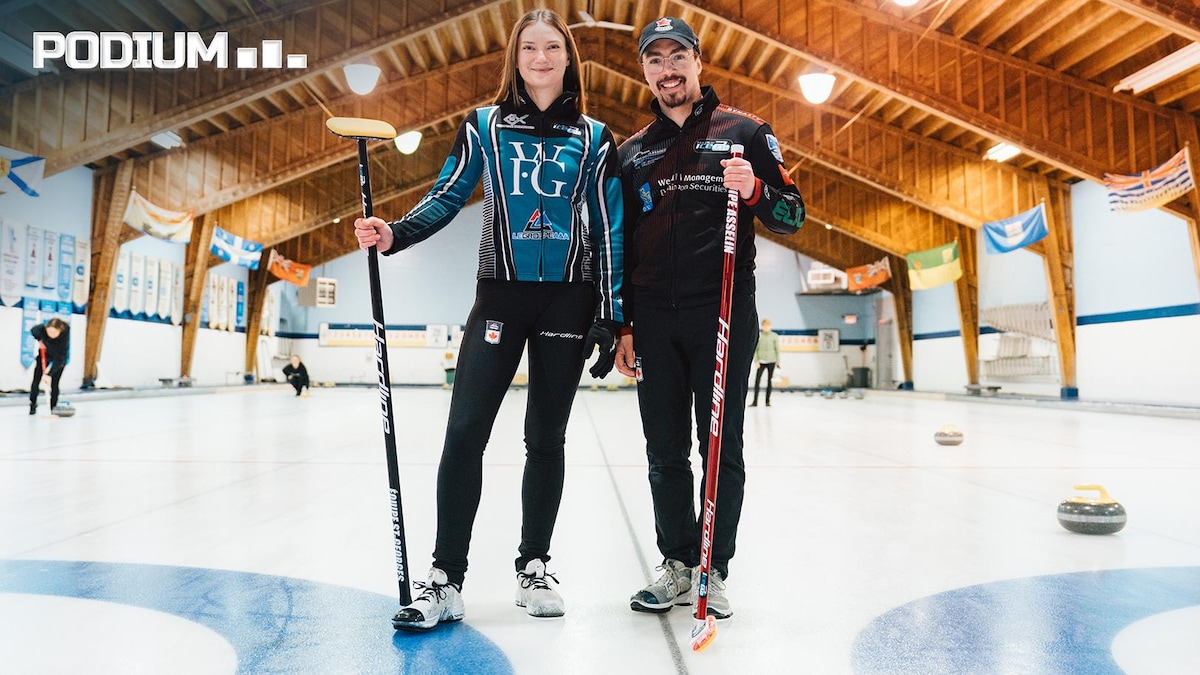 Deux joueurs de curling, une femme et un homme, sourient sur la glace, balais à la main.