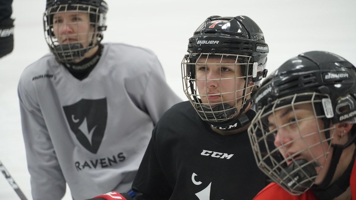 Des joueuses de hockey écoutent les directives de leurs entraîneurs agenouillées sur la patinoire.
