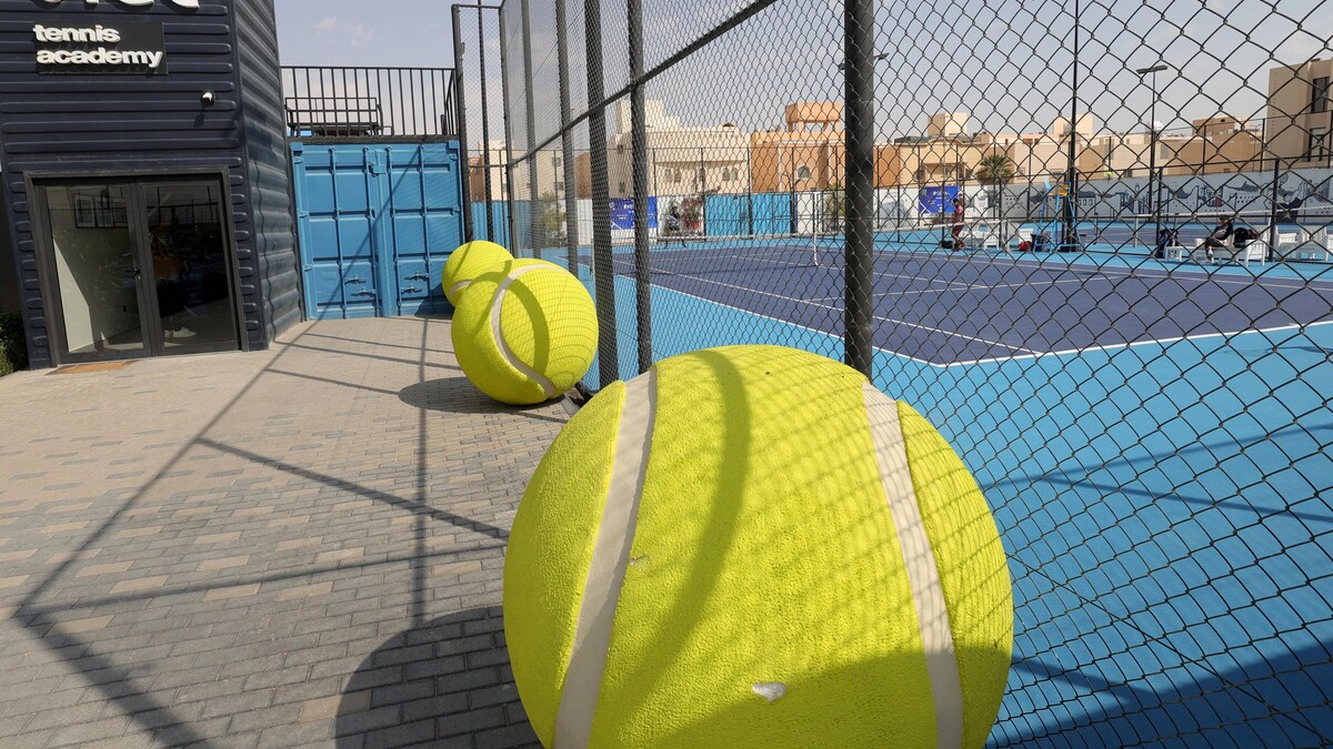 Des terrains de tennis entourés d'une clôture métallique.