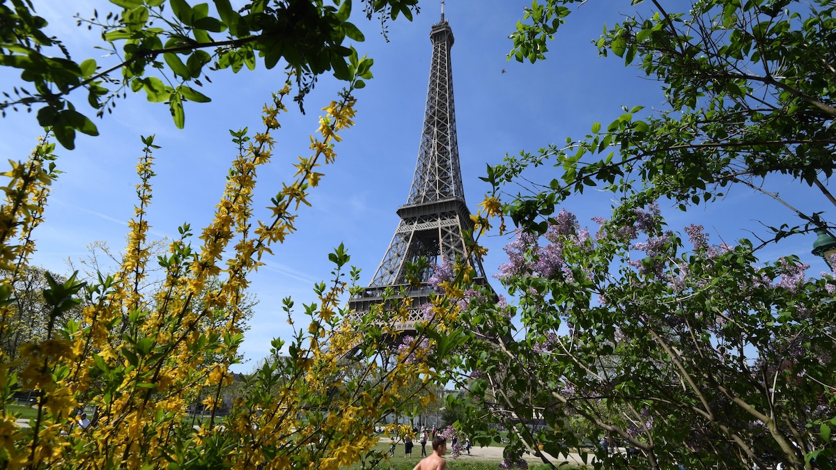 Un homme fait du jogging devant la tour Eiffel.