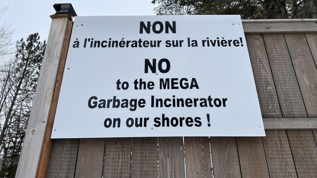 Une affiche, apposée sur une clôture de bois, sur laquelle il est écrit « NON à l'incinérateur sur la rivière! ».