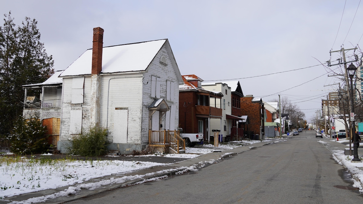 Une vieille maison allumette sur une rue résidentielle.