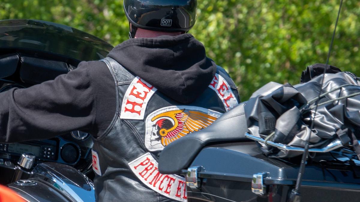 Gros plan sur la veste d'un homme à moto. On voit le logo des Hells Angels et la mention de la bande de motards et de la province de l'Île-du-Prince-Édouard.