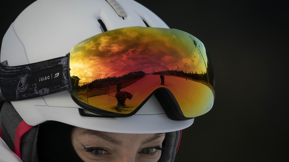 Dans les lunettes de ski, le reflet de  la pente qu'emprunte un skieur.