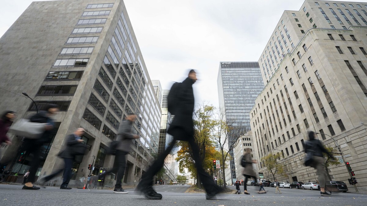 Des passants marchent au centre-ville de Montréal.