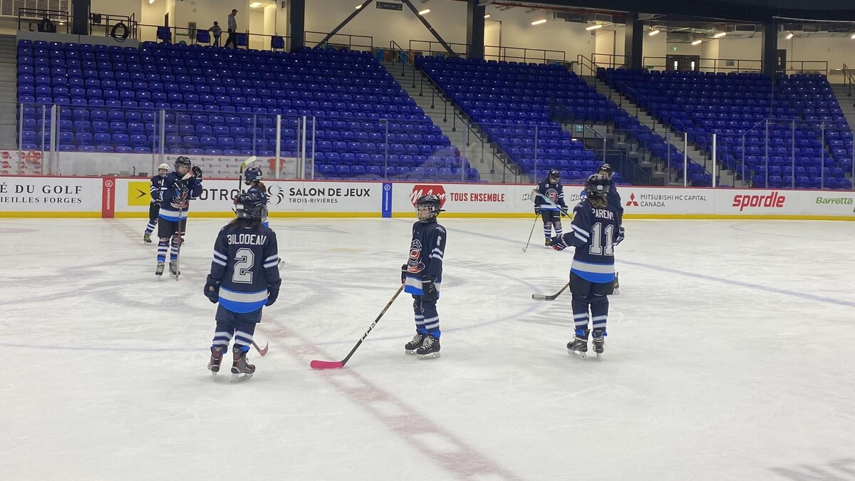 Des hockeyeuses au centre d’une patinoire.