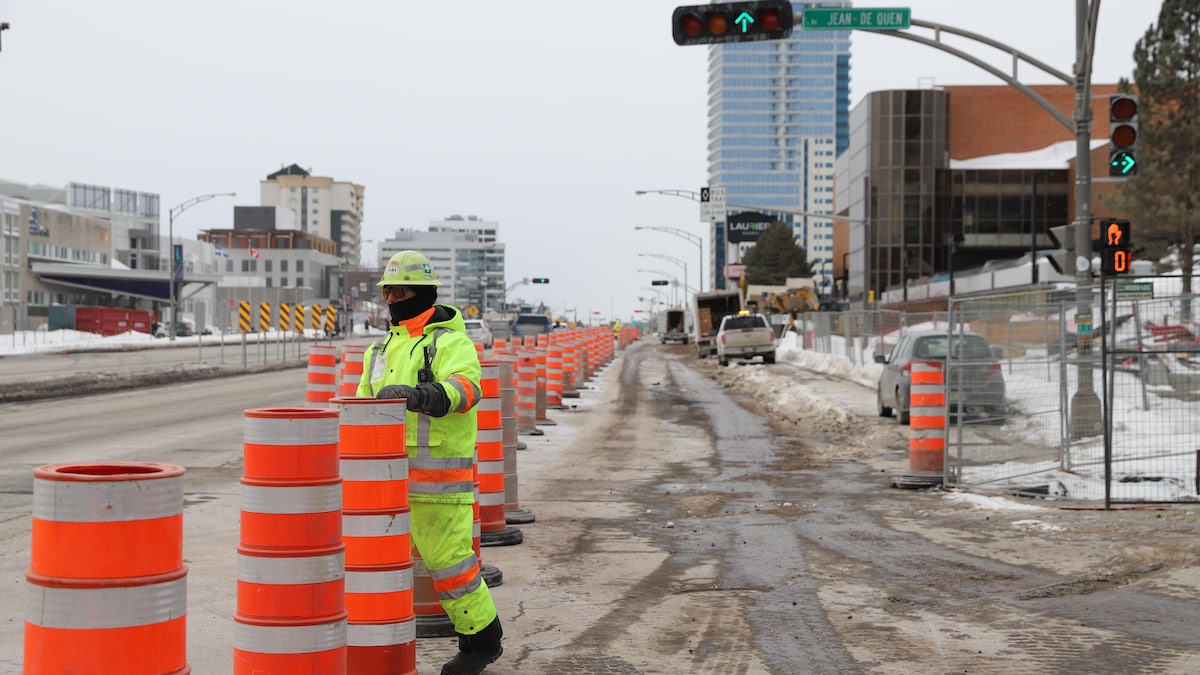 Un signaleur aux abords d'un chantier de construction devant le centre commercial Laurier Québec.