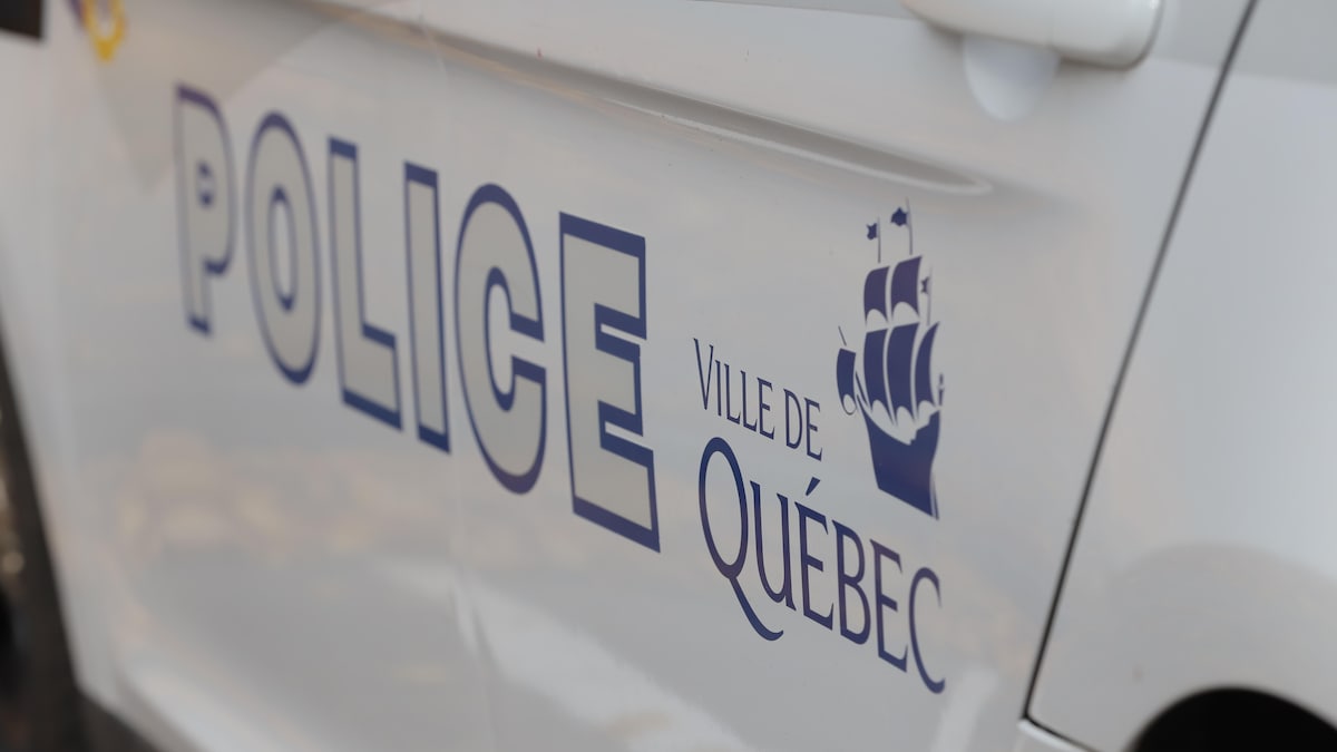 Les mots police et Ville de Québec sont écrits sur une portière de véhicule.
