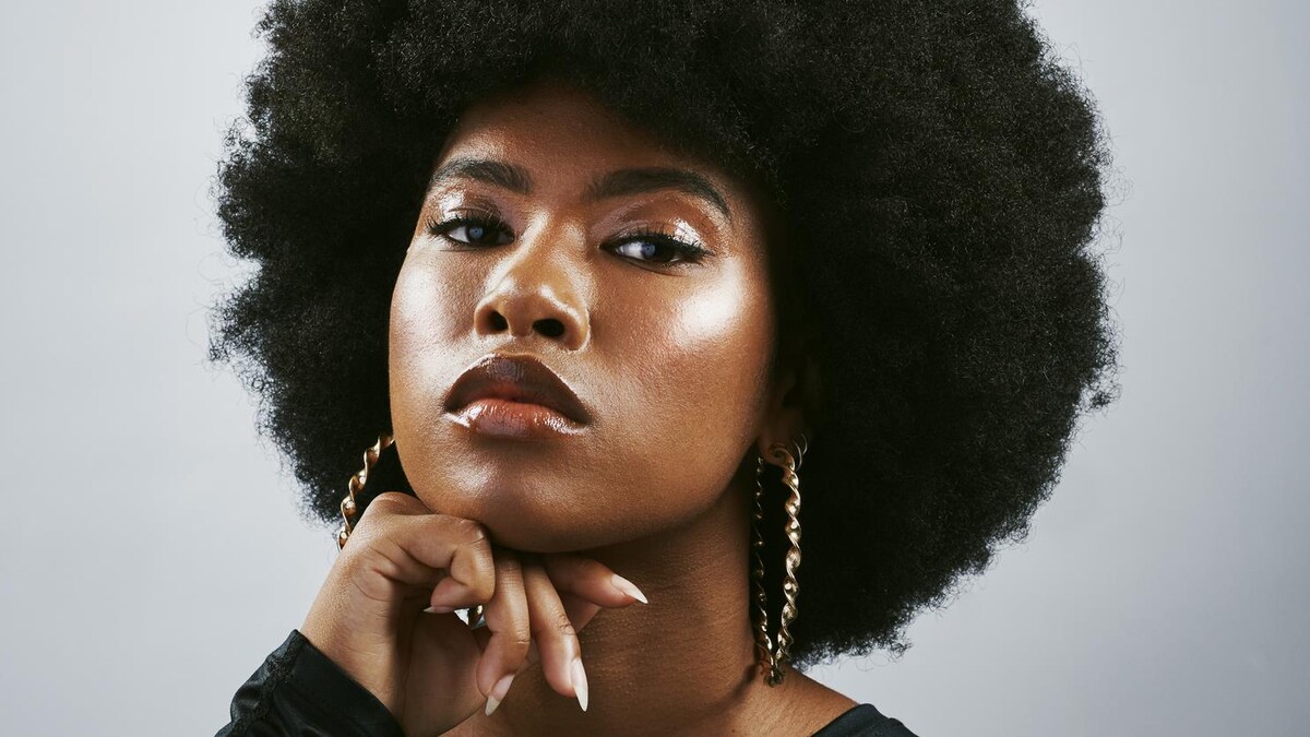  Femme confiante aux cheveux bouclés fière de sa coiffure.