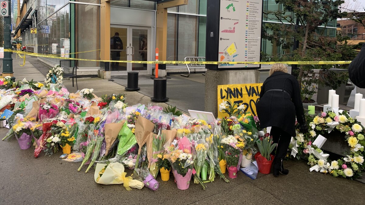 Plusieurs bouquets de fleurs et de mots sont placés devant le centre Lynn Valley Village à North Vancouver.
