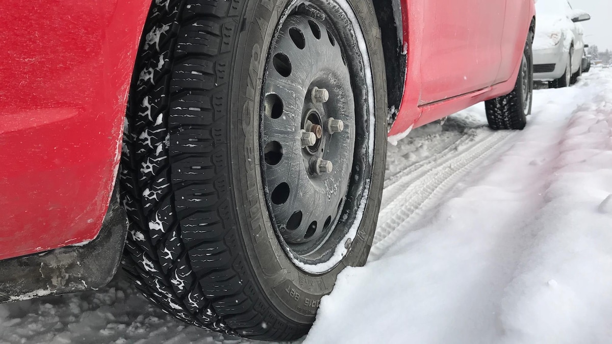Un voiture garé dans une rue enneigée.