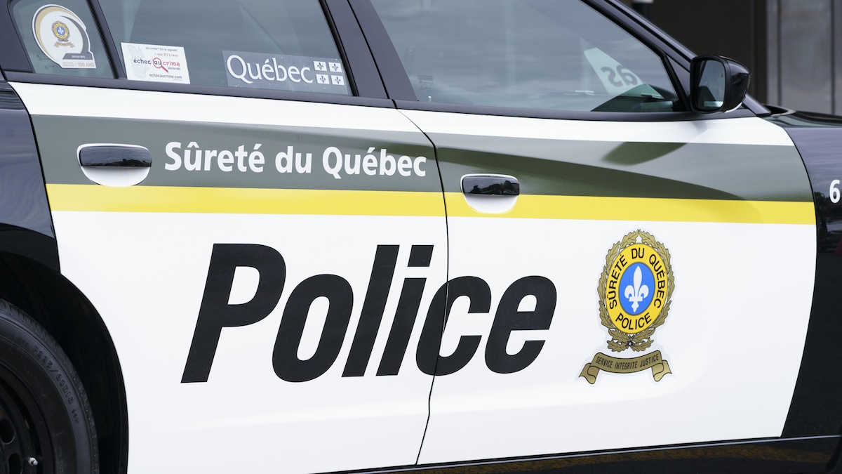 Une voiture de police affichant le logo de la Sûreté du Québec et le mot « Police ».