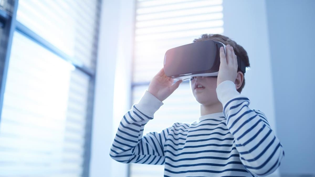 Un garçon joue avec un casque de réalité virtuelle.