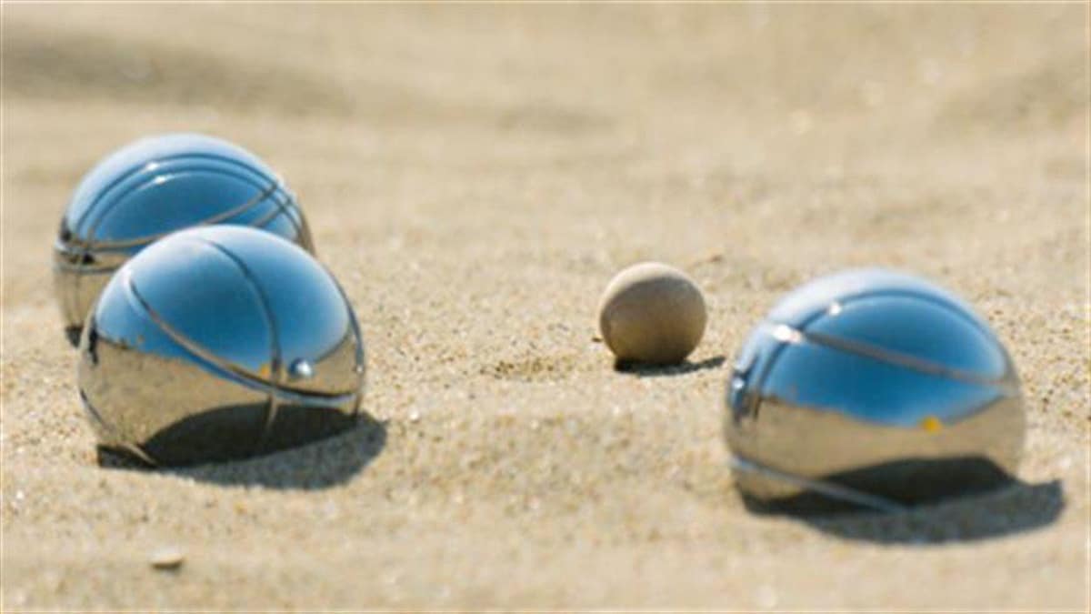 Des boules de pétanque dans le sable.