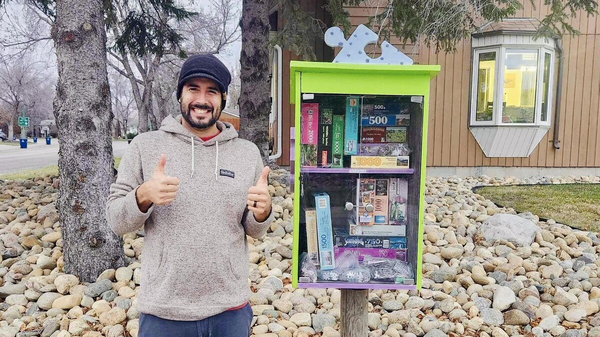 Le Fransaskois André Patenaude devant sa bibliothèque d'échange de casse-têtes à Saskatoon, en Saskatchewan, en novembre 2023.