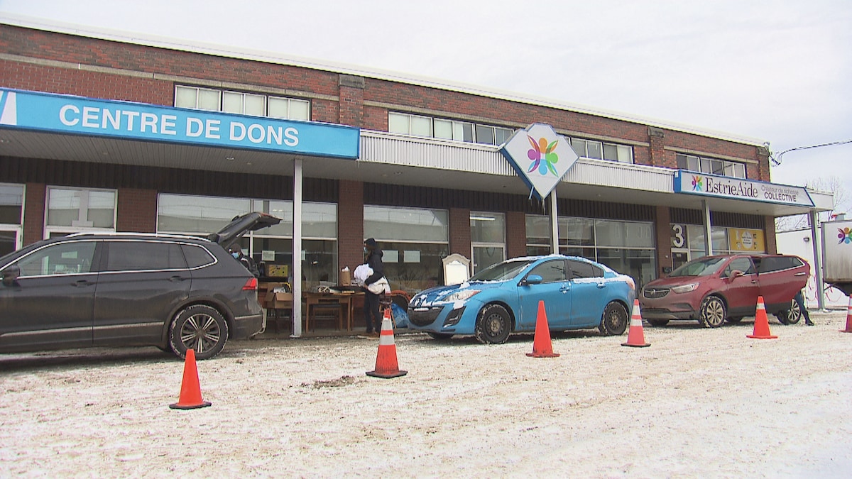 Trois voitures sont stationnées devant le centre de dons Estrie-Aide. 