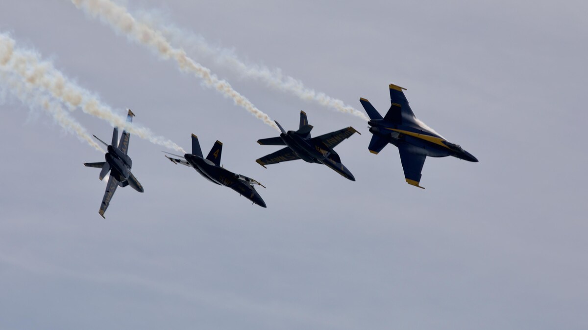 Quatre avions de chasse font de la voltige en groupe.