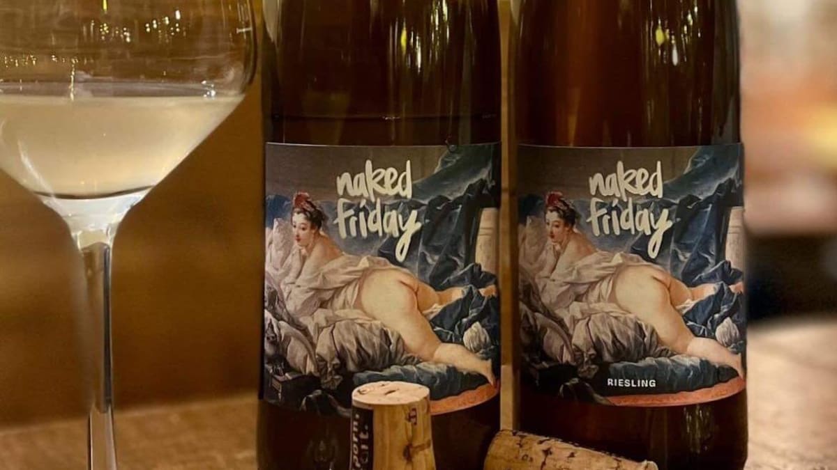 Deux bouteilles de vin et une coupe. Sur l'étiquette, il y a une toile de la Renaissance où on voit une femme à plat ventre, les fesses nues.