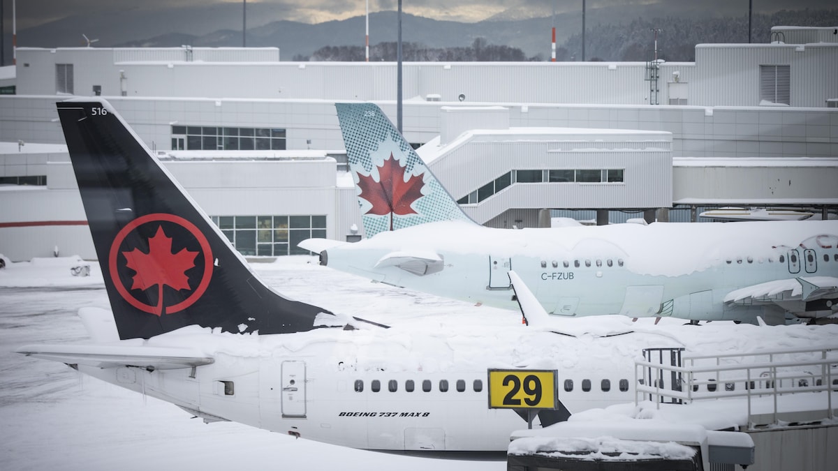 Des avions d'Air Canada enneigés à l'aéroport international de Vancouver.