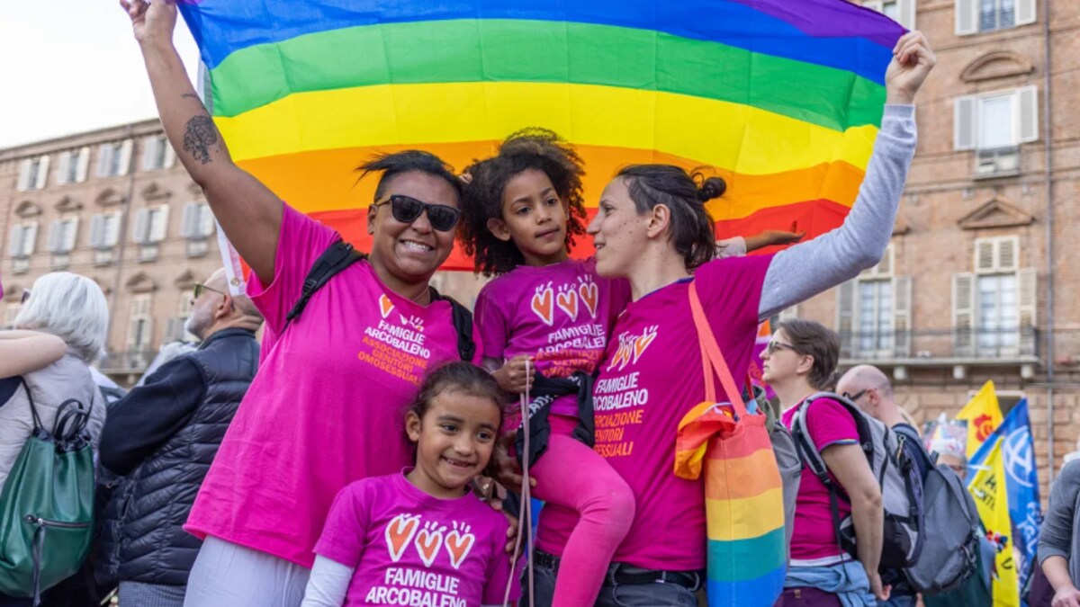 Deux femmes avec leurs deux filles tiennent un drapeau arc-en-ciel à une manifestation à Milan en mars dernier.  
