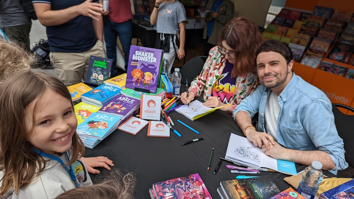 Des auteurs bédéistes de la bande dessinée Adèle signent les copies des enfants au Festival de la BD de Montréal. 