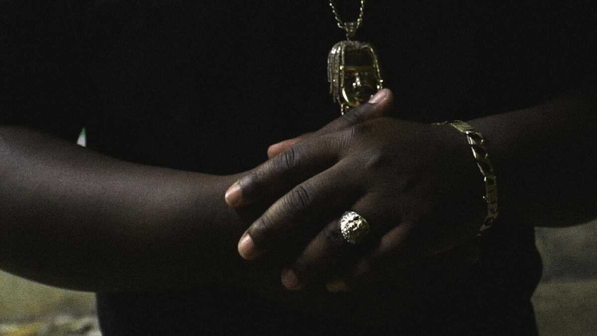 Les mains du rappeur Izzy-S, avec des bijoux en or.